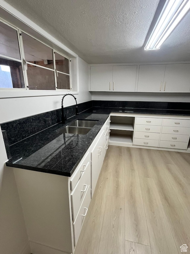 3374 Eccles E, Ogden, UT 84403 - kitchen with light wood finished floors, a sink, a textured ceiling, and dark stone counters