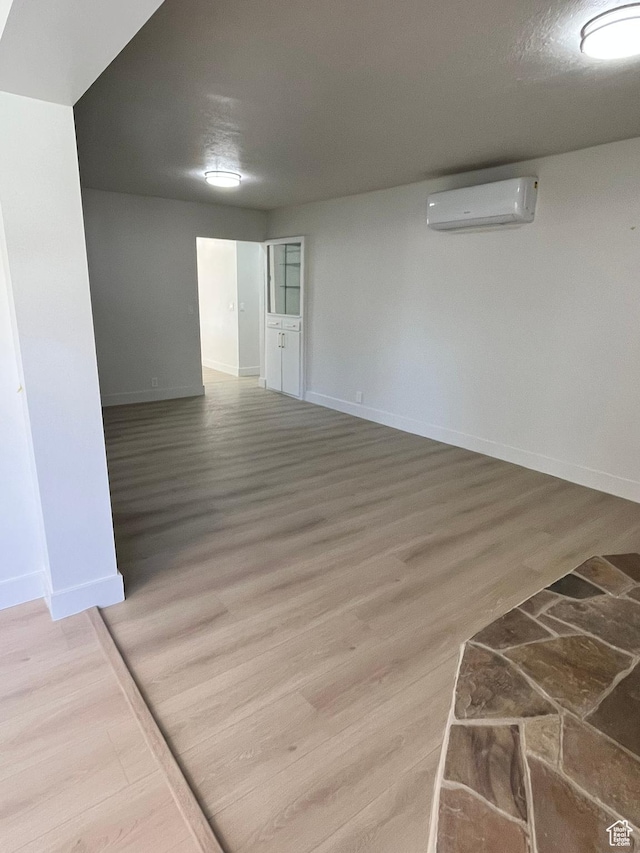 3374 Eccles E, Ogden, UT 84403 - empty room with an AC wall unit, baseboards, and wood finished floors