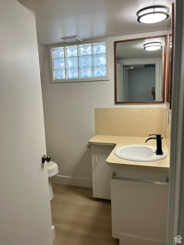 3374 Eccles E, Ogden, UT 84403 - half bathroom with baseboards, wood finished floors, vanity, and toilet