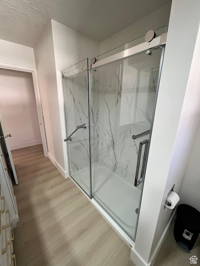 3374 Eccles E, Ogden, UT 84403 - bathroom with wood finished floors, a textured ceiling, baseboards, and a marble finish shower