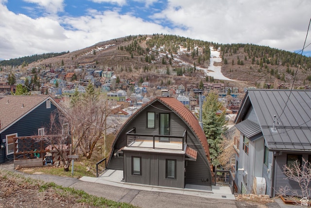 back of house featuring a residential view, a balcony, and a mountain view