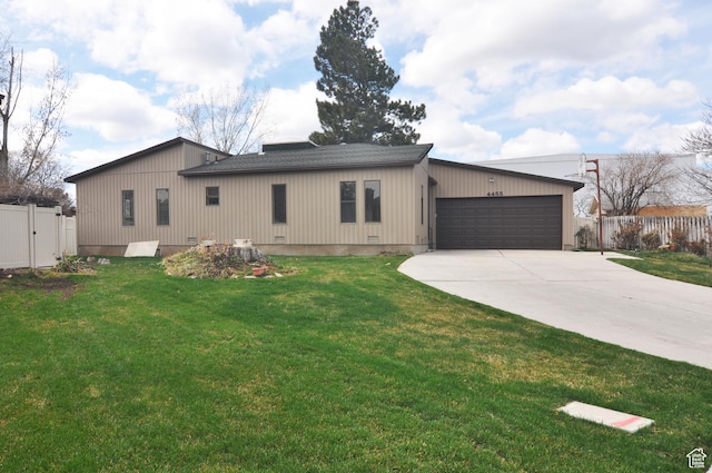 view of front of house with concrete driveway, a front lawn, fence, and an attached garage