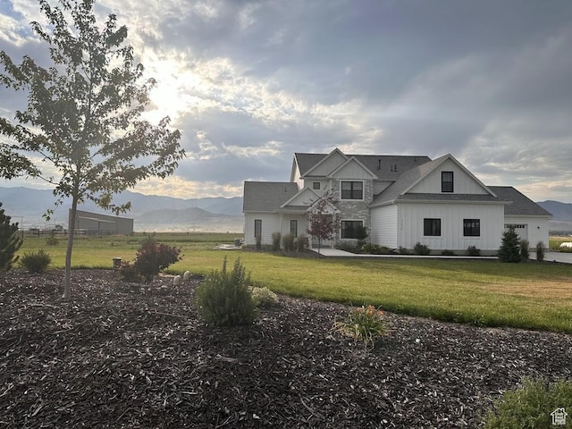 7226 Estancia Ln, Smithfield, UT 84335 - view of front of home featuring board and batten siding, a front yard, and a mountain view