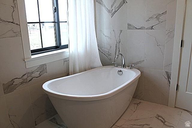 7226 Estancia Ln, Smithfield, UT 84335 - bathroom featuring marble tiled flooring, tile walls, and a soaking tub