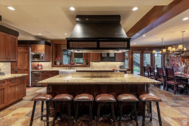 57 E 445 S, Garden City, UT 84028 - kitchen featuring ventilation hood, a sink, stainless steel microwave, tasteful backsplash, and stone tile floors