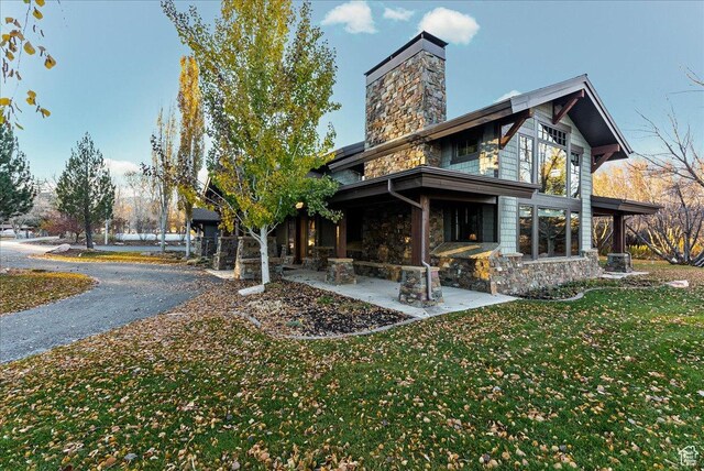 57 E 445 S, Garden City, UT 84028 - back of property with stone siding, a patio area, a chimney, and a yard