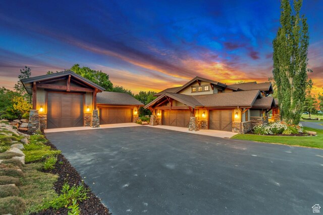 57 E 445 S, Garden City, UT 84028 - view of front of house featuring stone siding, an attached garage, and driveway