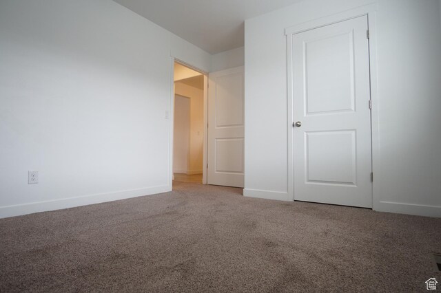 unfurnished bedroom featuring carpet floors and baseboards