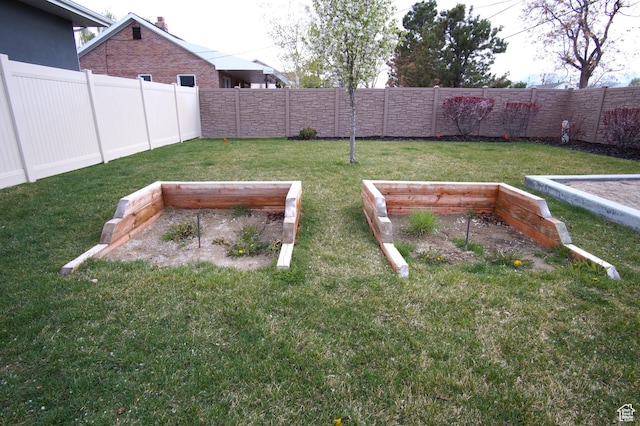view of yard featuring a garden and a fenced backyard