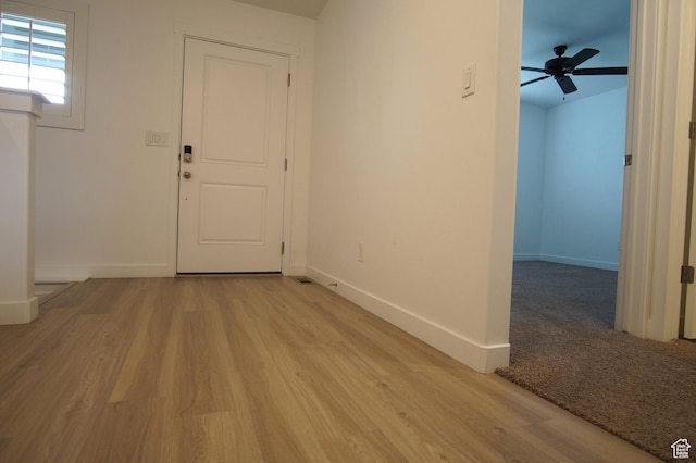 entryway featuring a ceiling fan, baseboards, and light wood-style floors