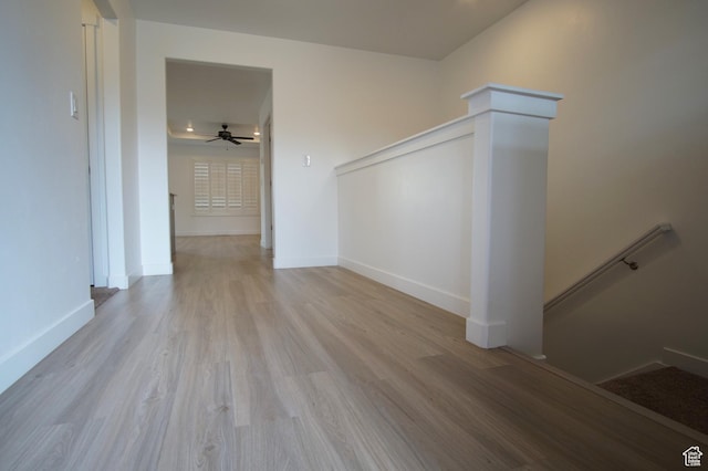 interior space with ceiling fan, baseboards, and light wood finished floors