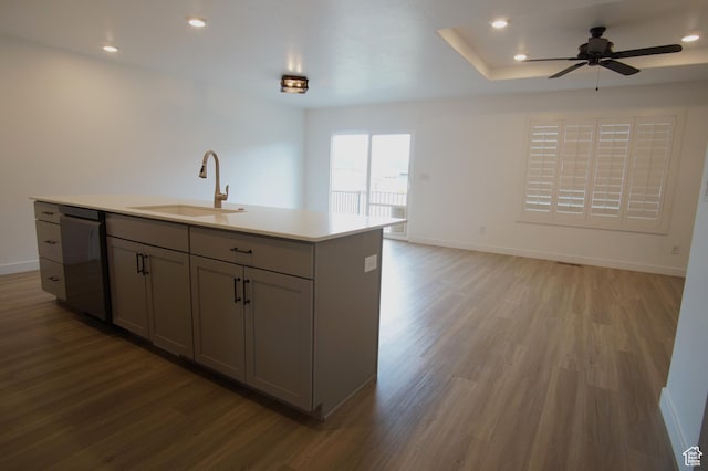 kitchen featuring light wood finished floors, gray cabinetry, a sink, and black dishwasher