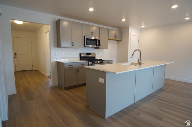 kitchen with dark wood-style floors, a sink, appliances with stainless steel finishes, and gray cabinets