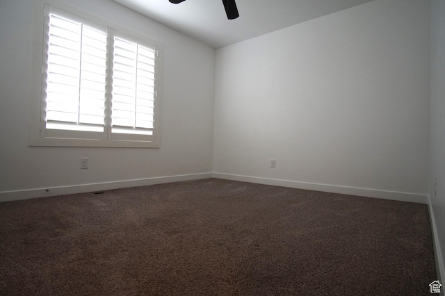 carpeted spare room with baseboards and a ceiling fan