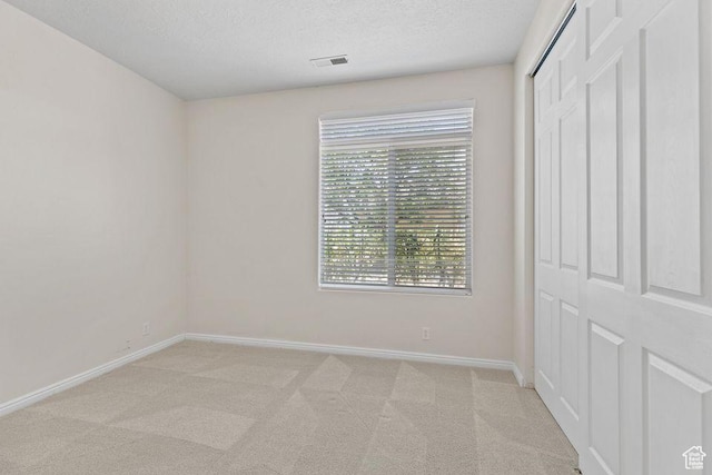 890 N Sky Mountain Ct, Hurricane, UT 84737 - unfurnished bedroom with baseboards, light colored carpet, a closet, and a textured ceiling