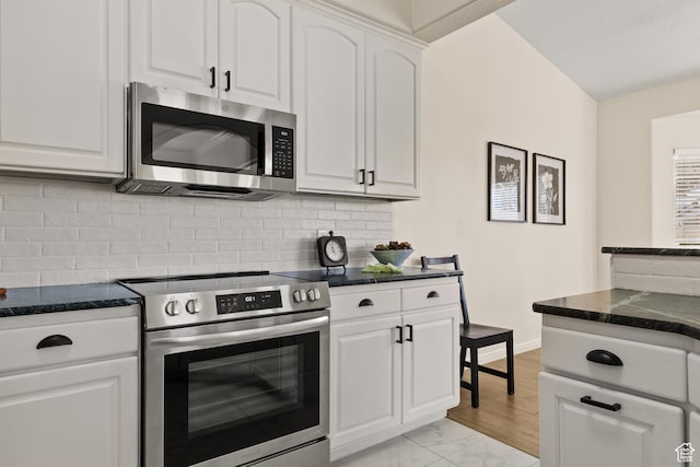 890 N Sky Mountain Ct, Hurricane, UT 84737 - kitchen with stainless steel appliances, white cabinetry, backsplash, light marble finish floors, and dark stone counters