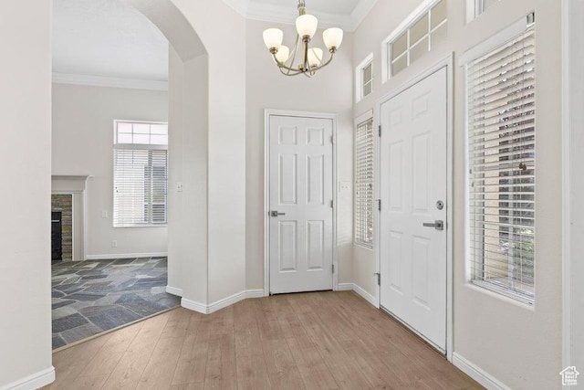 890 N Sky Mountain Ct, Hurricane, UT 84737 - entryway with arched walkways, ornamental molding, a chandelier, light wood-type flooring, and baseboards