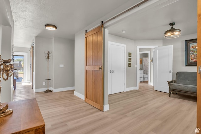 9185 S 200 W, Paradise, UT 84328 - corridor featuring light wood-type flooring, baseboards, a textured ceiling, and a barn door