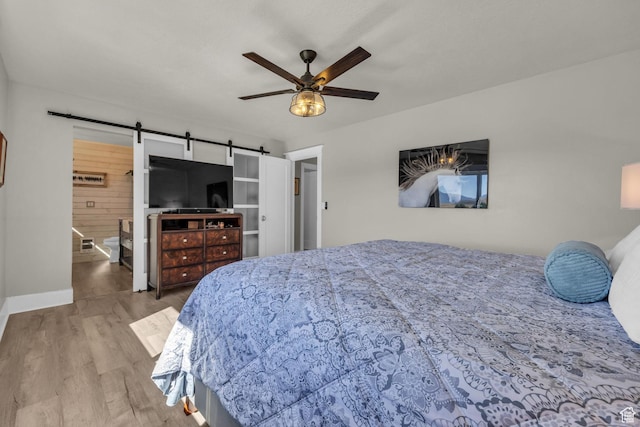 9185 S 200 W, Paradise, UT 84328 - bedroom featuring a barn door, wood finished floors, and ceiling fan
