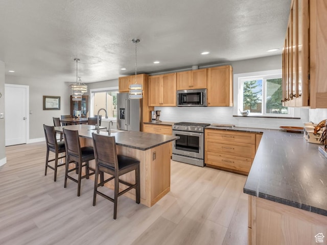 9185 S 200 W, Paradise, UT 84328 - kitchen with plenty of natural light, stainless steel appliances, dark countertops, a sink, and a kitchen bar