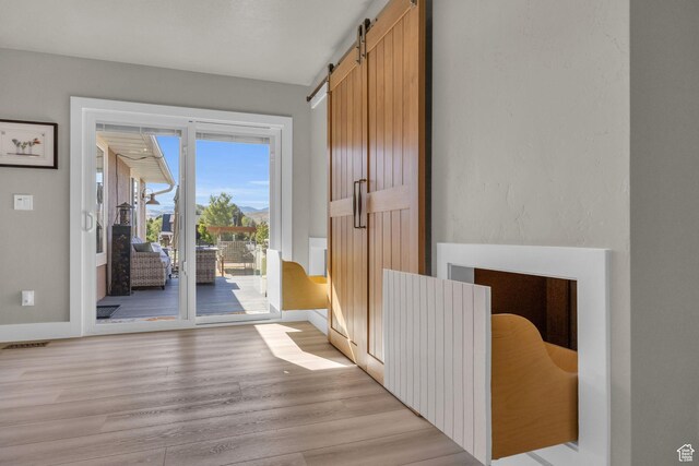 9185 S 200 W, Paradise, UT 84328 - doorway with a barn door, light wood-style floors, and baseboards