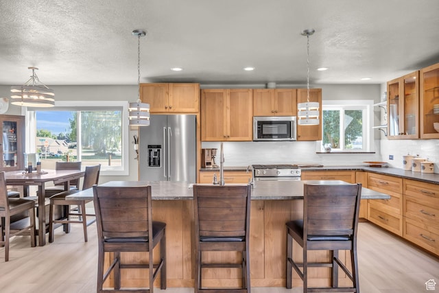 9185 S 200 W, Paradise, UT 84328 - kitchen with dark countertops, tasteful backsplash, a textured ceiling, stainless steel appliances, and light wood finished floors