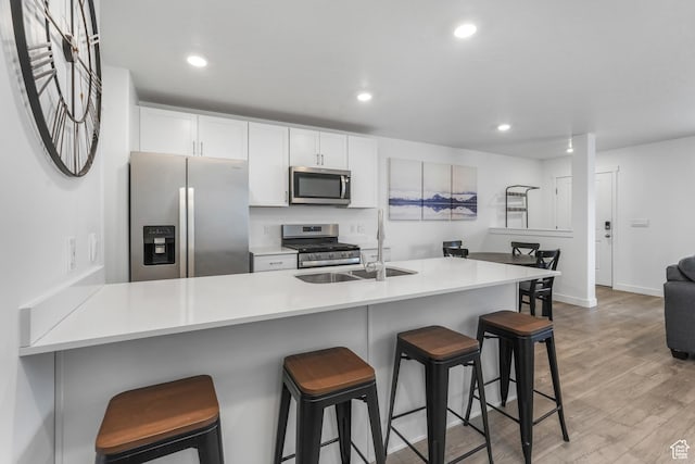 488 N Trident Dr, Saratoga Springs, UT 84045 - kitchen with white cabinetry, light wood-style flooring, stainless steel appliances, and a sink