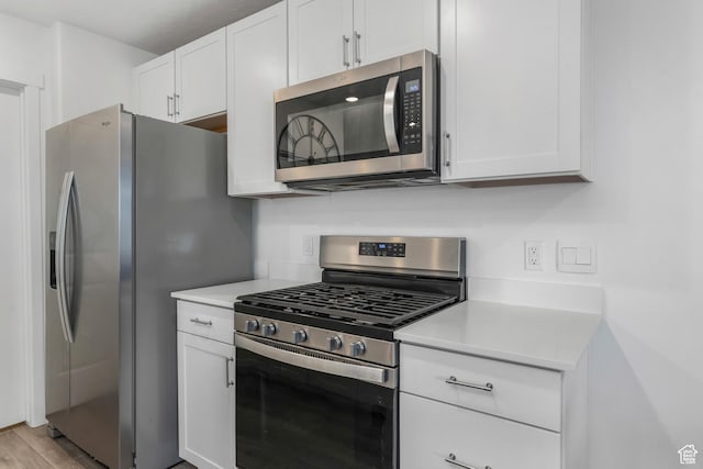 488 N Trident Dr, Saratoga Springs, UT 84045 - kitchen with light countertops, light wood-type flooring, white cabinetry, and stainless steel appliances