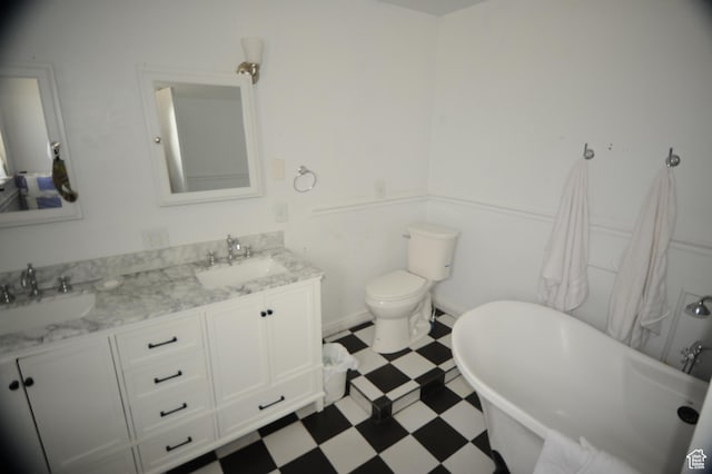 bathroom featuring a freestanding bath, double vanity, tile patterned floors, and a sink