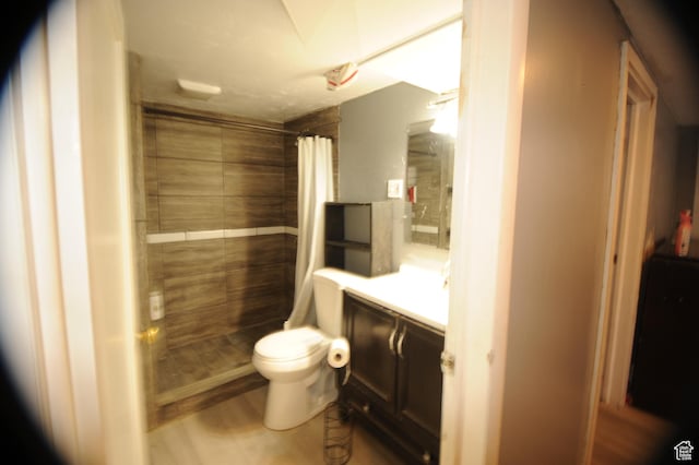 bathroom featuring vanity, toilet, and tiled shower
