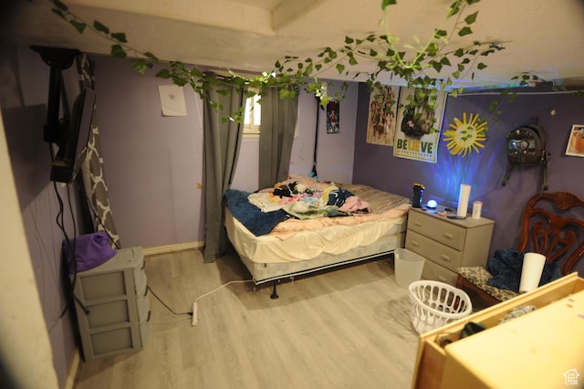 bedroom featuring wood finished floors and baseboards