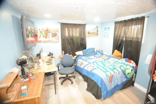 bedroom featuring wood finished floors, a textured ceiling, and recessed lighting