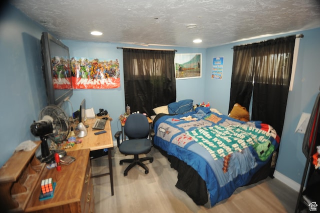 bedroom featuring recessed lighting, wood finished floors, a textured ceiling, and baseboards