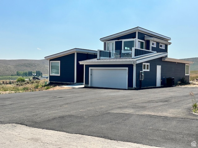 2747 S Country Club Way, Garden City, UT 84028 - view of front facade featuring an attached garage, asphalt driveway, a balcony, and a mountain view