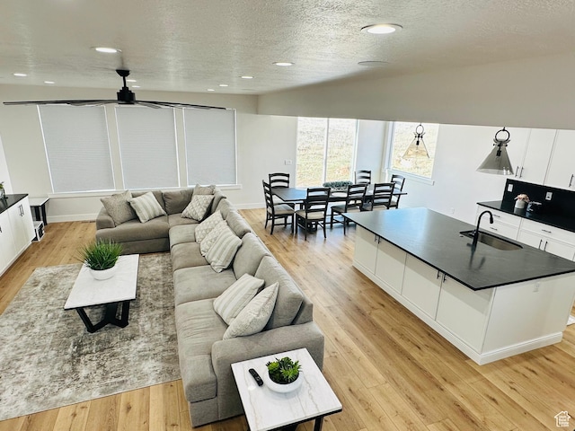 2747 S Country Club Way, Garden City, UT 84028 - living room featuring a ceiling fan, light wood-type flooring, a textured ceiling, and recessed lighting