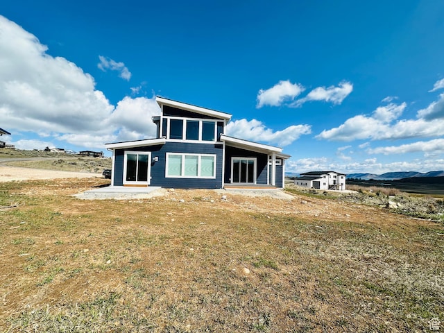 2747 S Country Club Way, Garden City, UT 84028 - rear view of house with a patio, a yard, and a mountain view