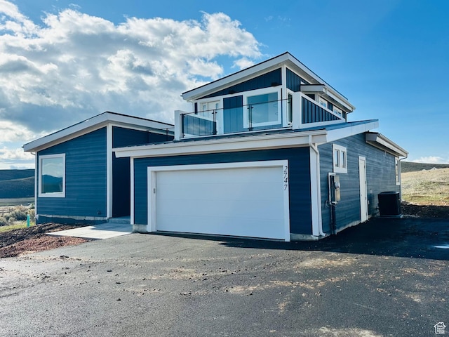 2747 S Country Club Way, Garden City, UT 84028 - view of front of home featuring a balcony, a garage, and asphalt driveway