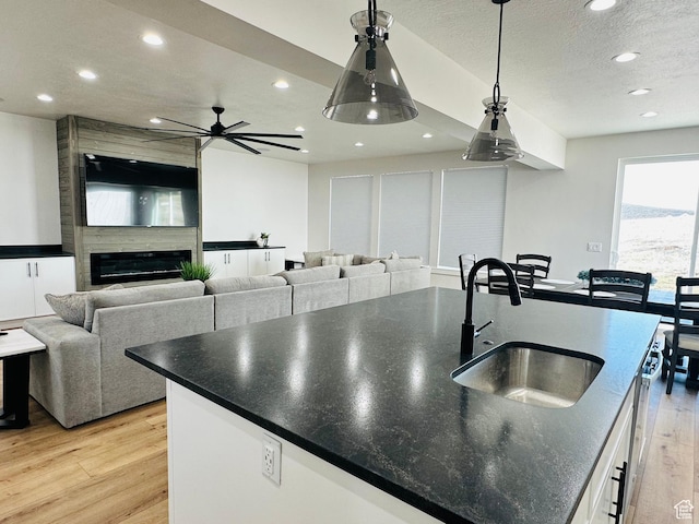2747 S Country Club Way, Garden City, UT 84028 - kitchen featuring light wood-type flooring, recessed lighting, a center island with sink, pendant lighting, and white cabinetry