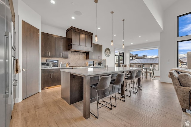 1622 E Abajo Peak Cir Unit Tv-23, Heber City, UT 84032 - kitchen featuring dark brown cabinets, a kitchen island with sink, a breakfast bar, and backsplash