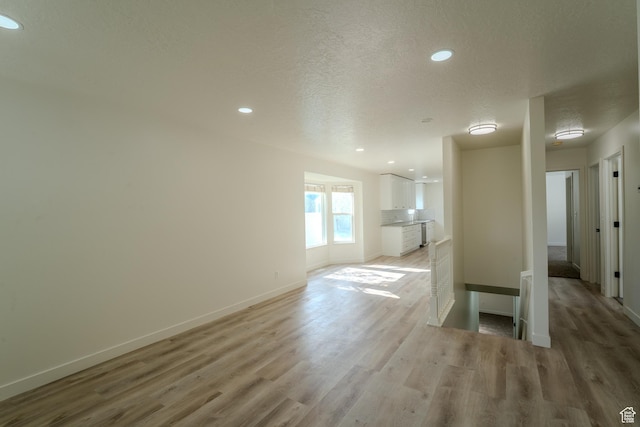 2976 E Saddle Rock Rd, Eagle Mountain, UT 84005 - unfurnished living room featuring recessed lighting, light wood-style floors, a textured ceiling, and baseboards