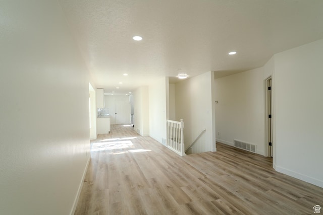 2976 E Saddle Rock Rd, Eagle Mountain, UT 84005 - interior space with light wood-type flooring, baseboards, visible vents, recessed lighting, and an upstairs landing