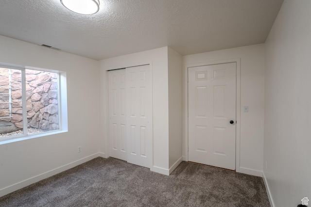 2976 E Saddle Rock Rd, Eagle Mountain, UT 84005 - unfurnished bedroom featuring a textured ceiling, a closet, baseboards, carpet flooring, and visible vents