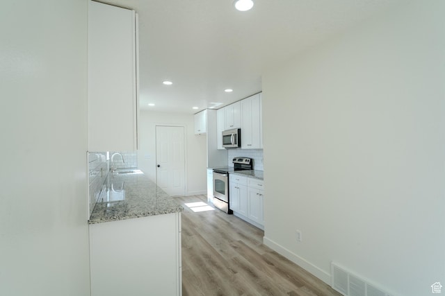 2976 E Saddle Rock Rd, Eagle Mountain, UT 84005 - kitchen with a sink, decorative backsplash, white cabinets, appliances with stainless steel finishes, and recessed lighting