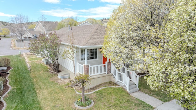 2976 E Saddle Rock Rd, Eagle Mountain, UT 84005 - view of side of home featuring a lawn, a porch, and a shingled roof