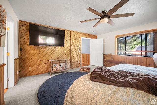 835 E Mountain View Dr, Pine Valley, UT 84781 - bedroom featuring a textured ceiling, wooden walls, ceiling fan, carpet floors, and baseboards