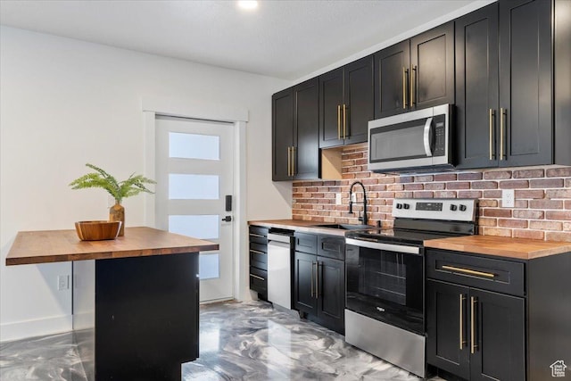 5651 W Meadow Cir, Mountain Green, UT 84050 - kitchen featuring backsplash, butcher block counters, appliances with stainless steel finishes, and a sink