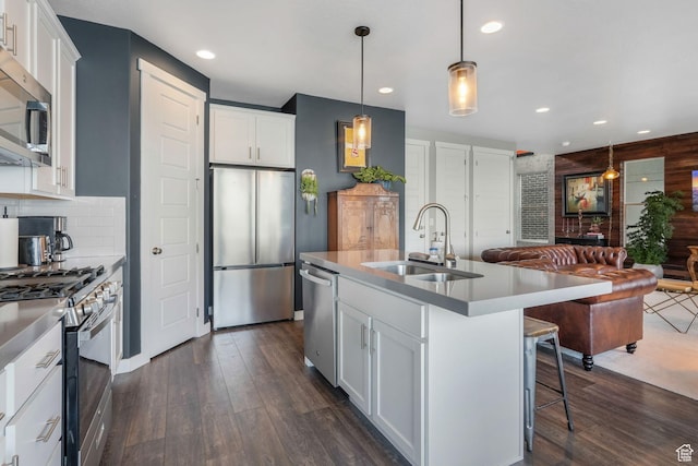 kitchen featuring stainless steel appliances, dark wood-style floors, a sink, recessed lighting, and white cabinetry