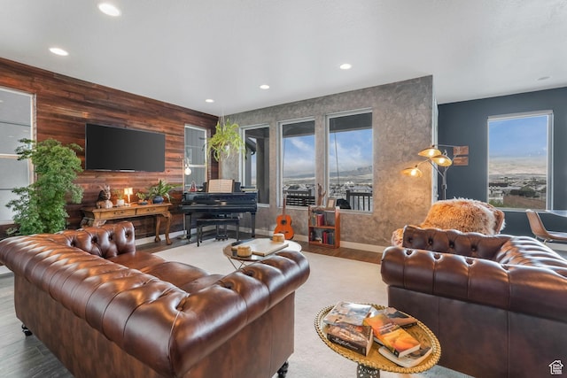 living room featuring a healthy amount of sunlight, wood finished floors, wooden walls, and recessed lighting