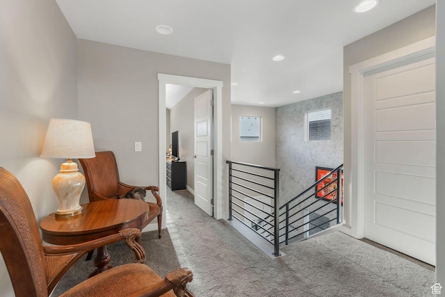 living area featuring recessed lighting, carpet floors, and an upstairs landing