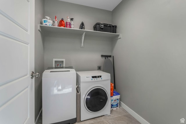 laundry room with washing machine and dryer, baseboards, and laundry area